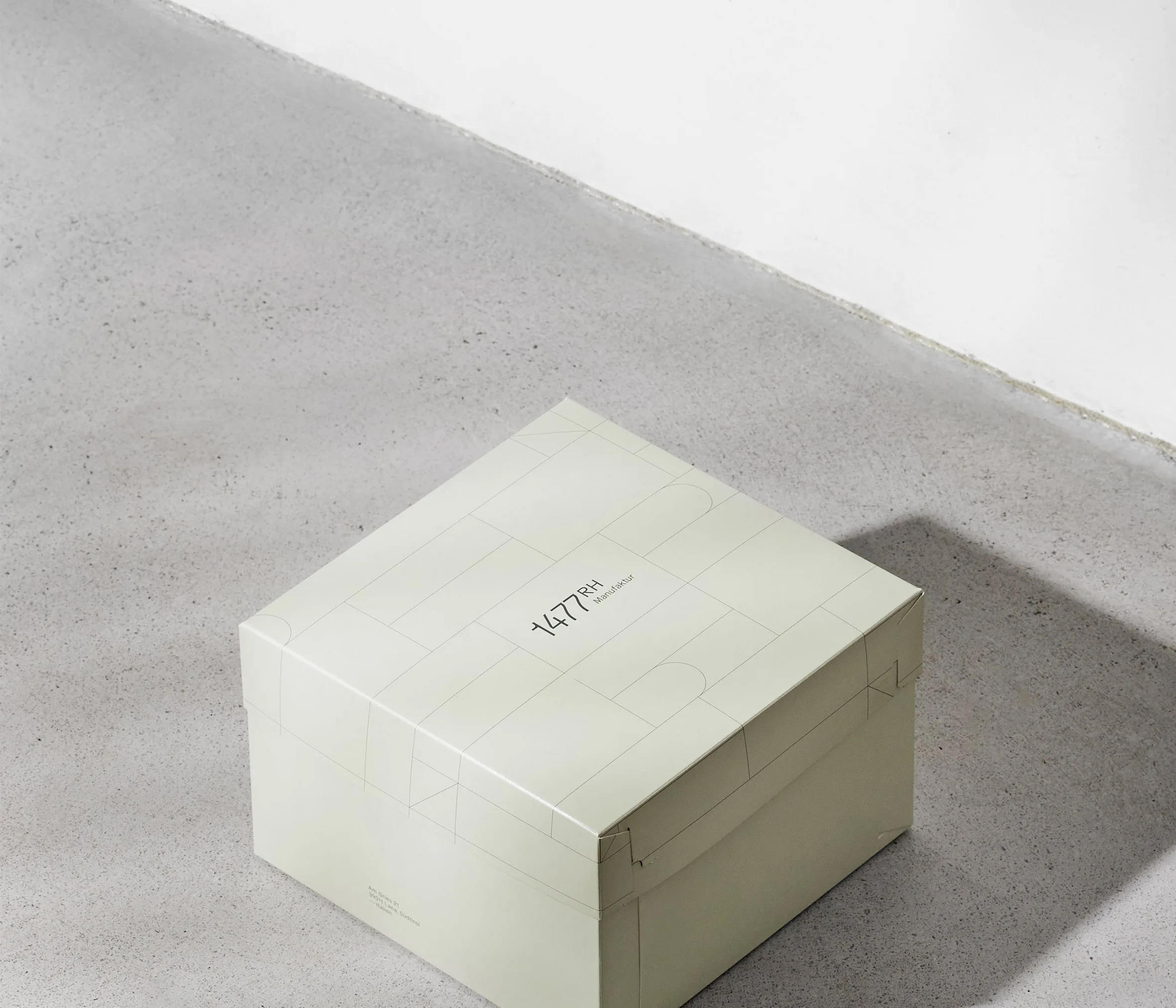 Cremefarbene Verpackungsbox mit feiner typografischer Gestaltung.